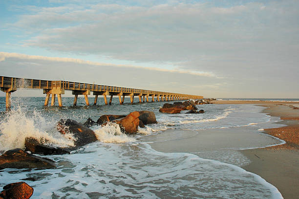 "Waves crashing against breakers along the pier on the northern end of Amelia Island, Florida.  Late afternoon sunlight."